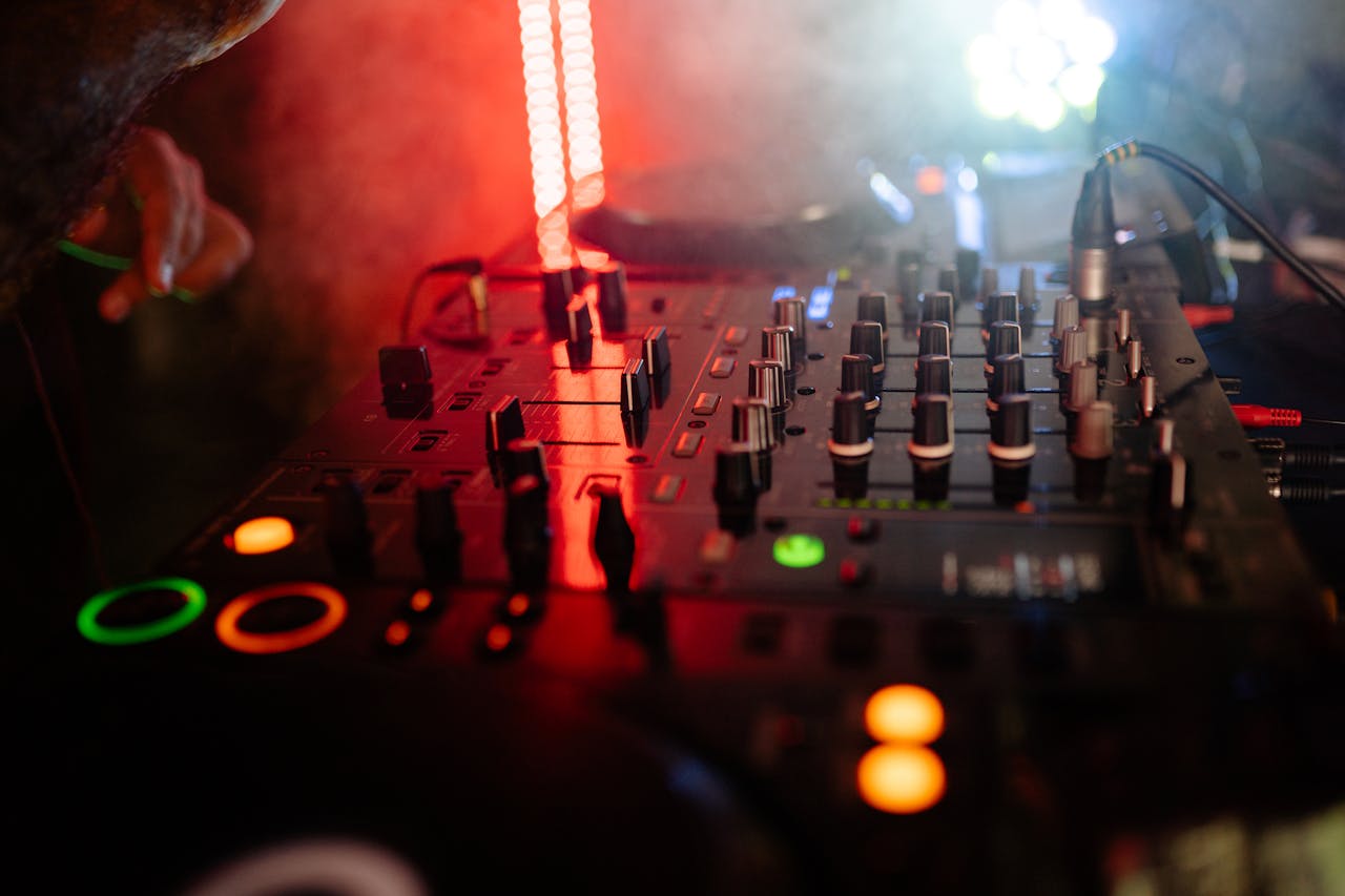 Dynamic close-up of a DJ mixer in a nightclub setting with colorful lights and atmospheric mood.
